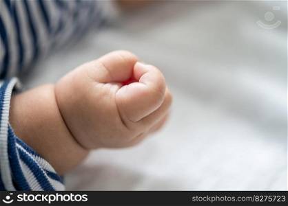Newborn baby hand in white bed. Se≤ctive focus.