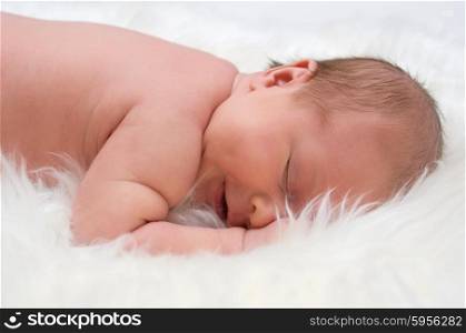 Newborn baby on white furs