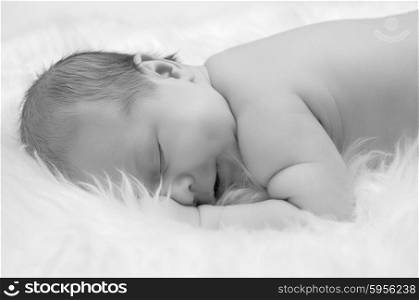 Newborn baby on white furs (monochrome)