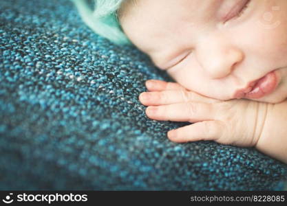 newborn baby sleeping sweetly on a blue background. newborn baby sleeping sweetly on a blue rug in blue cap