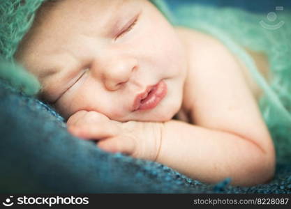 newborn baby sleeping sweetly on a blue background. newborn baby sleeping sweetly on a blue rug in blue cap