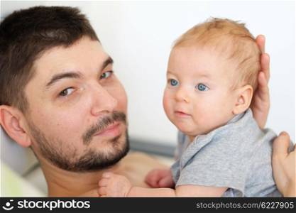 Newborn baby with his father. Shallow depth of field.