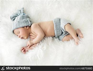 Newborn child sleeping on the white blanket