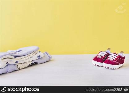 newborn concept with baby shoes pile clothes