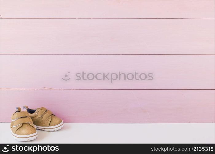 newborn concept with shoes space wooden surface