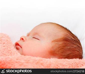 newborn cute baby sleeping under peachey blanket