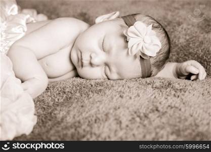 Newborn pretty baby girl in pink tutu dress sleeps on the purple textile. The newborn girl