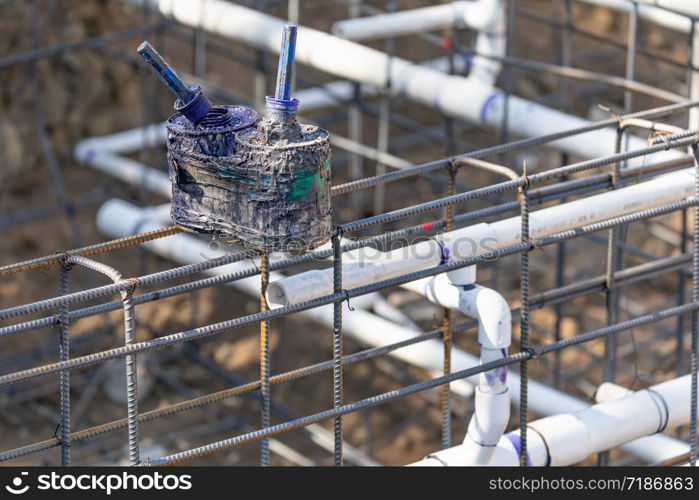 Newly Installed PVC Plumbing Pipes and Steel Rebar Configuration At Construction Site.