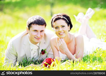 newly-married couple Lie on green grass in field