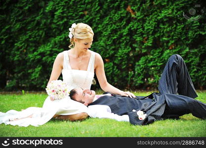 newly-married couple on green grass in field