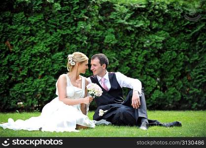 newly-married couple on green grass in field