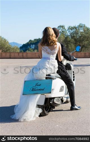 Newlywed couple leaving the wedding with their motorbike