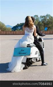 Newlywed couple leaving the wedding with their motorbike