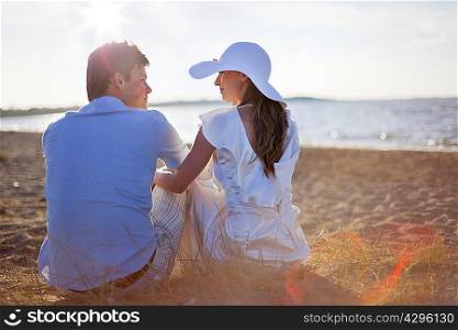 Newlywed couple sitting on beach