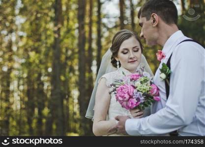 Newlyweds hugging on the background of the forest.. The tender embrace of the newlyweds in the woods 3948.