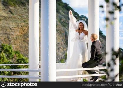 Newlyweds on a walk in the gazebo look at each other happily