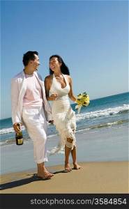 Newlyweds Walking on the Beach with Champagne