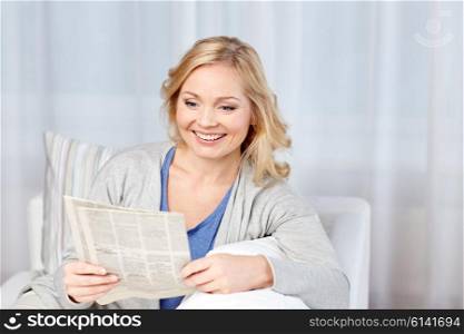 news, press, media, leisure and people concept - smiling woman reading newspaper at home