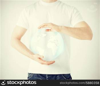 news, technology and environment concept - man hands holding sphere globe