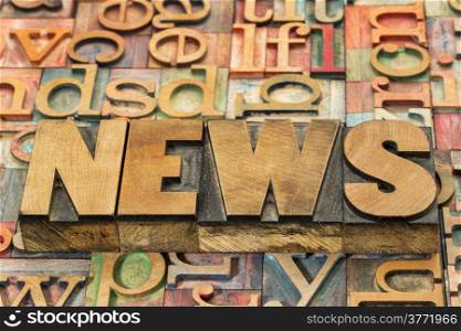 news word in wood type against background of letterpress printing blocks