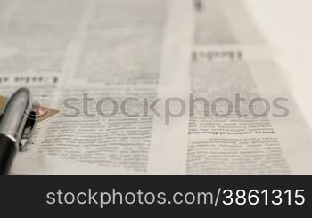 Newspaper, pen, magnifier glass and credit cards