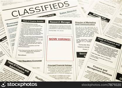 newspaper with advertisements and classifieds ads for vacancy, now hiring