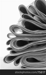 Newspapers folded and stacked on white background