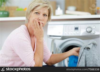 nhappy woman using washing machine at home