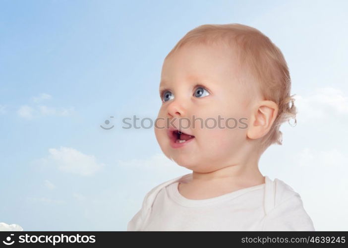 Nice baby with blue eyes with a beautiful sky of background