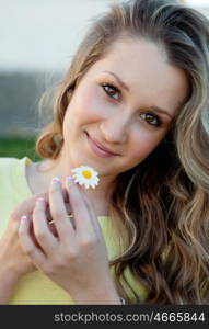 Nice blonde girl holding a daisy with face of love