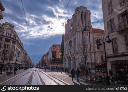 Nice, France, January 17, 2019 - The Basilica of Notre-Dame de Nice and busy street view. Town in French riviera. The basilica, built between 1864 and 1868, was designed by Louis Lenormand and is the largest church in Nice.