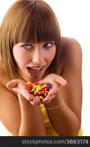 nice girl glancing on one side with colored lips and smarties in hand