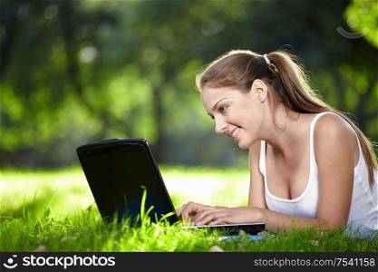 Nice girl looking at laptop monitor in the park