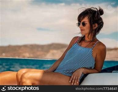 Nice Girl Tanning on the Sailboat. Luxury Summer Trip to Greece. Recreation on Water Transport. Enjoying Vacation on the Yacht.. Enjoying Vacation on Sailboat