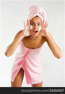 nice girl with pink towel cream on her face and a turban screaming
