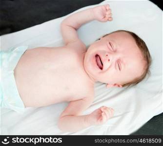Nice newborn in diaper crying inconsolably