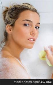 nice portrait of a blond girl in bathtub with foam all around in relax