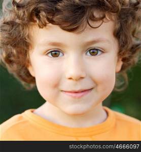 Nice portrait of a little boy with curly hair and brown eyes smiling