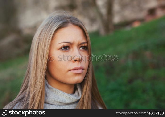 Nice portrait of blonde girl with green grass of background