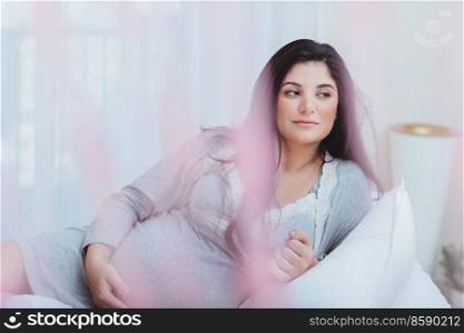 Nice Pregnant Woman with Pleasure Spending Time at Home. Resting on the Bed. Happy Healthy Mother to Be. Family Love Concept.. Beautiful Pregnant Woman at Home