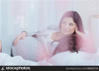 Nice Pregnant Woman with Pleasure Spending Time at Home. Resting on the Bed. Happy Healthy Parenthood. Family Love Concept.. Beautiful Pregnant Woman at Home