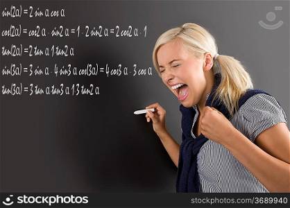nice school girl in panic , screaming in front of the blackboard, during a math lesson