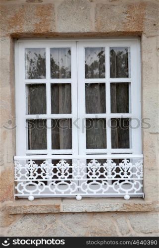 Nice window with white wrought into a stone wall