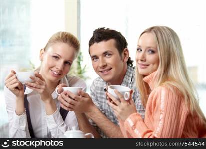 Nice young people drink coffee on a forward background