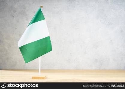 Nigeria table flag on white textured wall. Copy space for text, designs or drawings