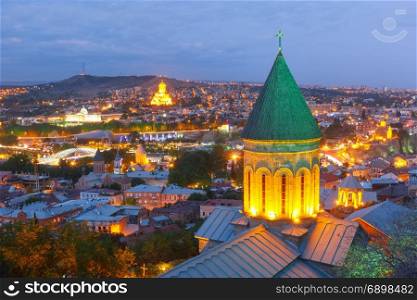 Night aerial view of Old Town, Tbilisi, Georgia. Aerial view of Old Town with dome of Lower Bethlemi Church and Sameba Holy Trinity Cathedral, Metekhi Church, bridge of Peace and Presidential Palace in night Illumination during evening blue hour, Tbilisi, Georgia.
