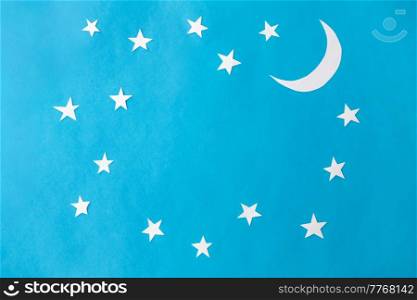 night, bedtime and object concept - moon and stars on blue paper background. moon and stars on blue night background