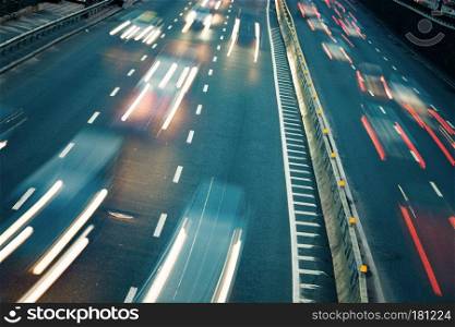 Night car traffic. Motion blur car viewed from the road bridge in big modern city.