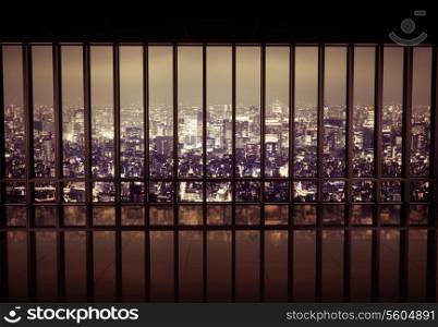 Night city behind the metal grating