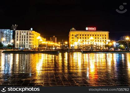 Night city landscape. The main square of the city of Khabarovsk in the light of lanterns, which are reflected in puddles after the rain just passed.. Khabarovsk, Russia - August 13, 2018  Lenin square at night under the light of lanterns.
